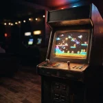 A glowing pixel arcade cabinet in a dark neon-lit gaming lounge, with a small trophy shelf in the background