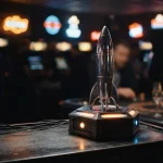 Silver rocket poised for launch in a neon-lit arcade, with a slot machine and warm amber gaming lights beyond