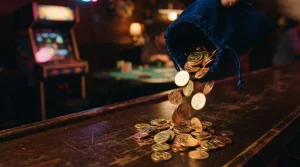 Golden coins spilling beside a vintage arcade machine in a dark neon-lit gaming lounge with a softly glowing game table