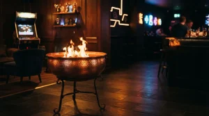 Copper brazier with lively orange flames in a dark neon-lit gaming lounge, with arcade machines and a trophy shelf behind it