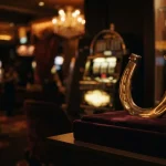 A gleaming golden horseshoe above a velvet lounge table, with a softly glowing casino arcade behind it