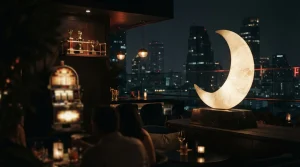 A luminous crescent moon sculpture in a dark rooftop lounge, with a softly glowing slot machine in the background